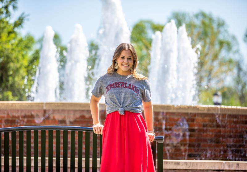 A Cumberlands student stands in front of the fountain in the quad