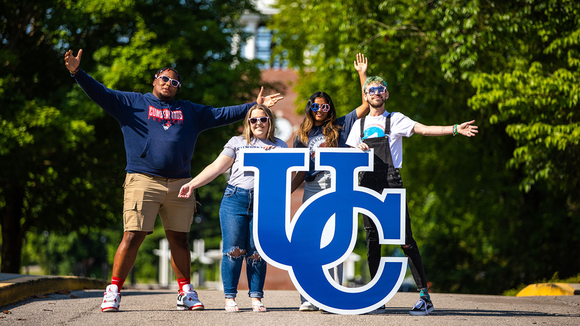 University of the Cumberlands student pose on campus with a UC sign. 