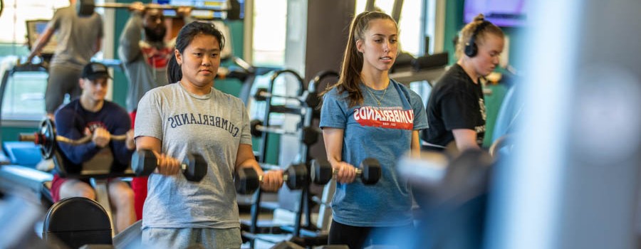 young adults working out in a weight room