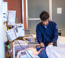 A nursing student works through an exam on a simulated patient. 
